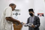 Ketua DPRK Farid Nyak Umar membagikan masker kain pada warga di Meunasah Baburrahman, Dusun E, Gp. Beurawe, Kecamatan Kuta Alam, Banda Aceh. Jumat malam (01/05/2020).